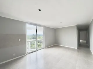 Sala ampla com grande janela e vista para a natureza.