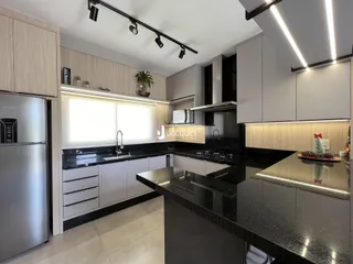 Interior de uma cozinha moderna com armários e bancadas escuras.