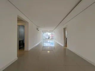 Corredor interno de uma residência com piso de cerâmica clara.