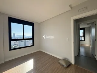 Sala de estar com grande janela oferecendo vista da cidade.