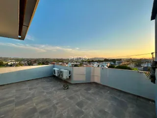 Vista de uma varanda com paisagem ao pôr do sol.