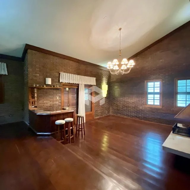 Uma sala de estar com paredes de tijolo aparente e piso de madeira.