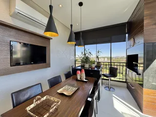 Vista de uma sala de jantar moderna com grandes janelas e decoração em madeira escura.