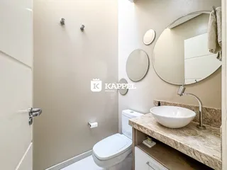 Foto de um banheiro com pia, vaso sanitário e espelho.
