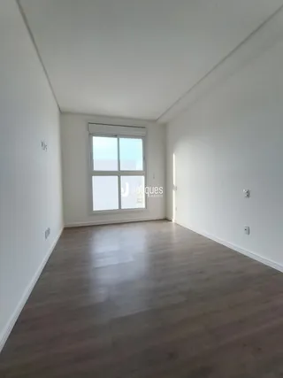 Ambiente interno com paredes brancas e piso de madeira claro.
