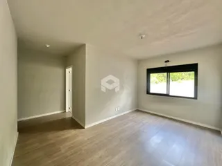 Foto de uma sala com piso de madeira clara e janela.