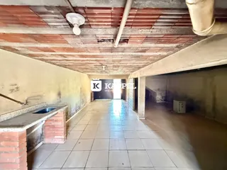 Corredor interno com piso de cerâmica e teto aparente.