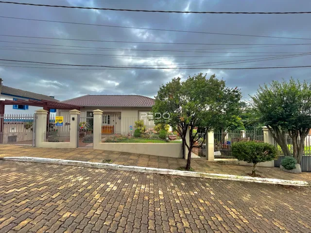 Fachada de uma residência em Lajeado, Brasil, com cerca e jardim na frente.