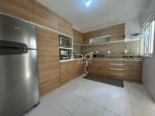 Foto de uma cozinha com armários de madeira e piso cerâmico claro.
