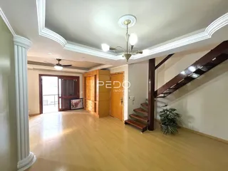 Sala de estar com piso de madeira clara e detalhes arquitetônicos brancos.