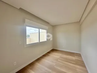Foto de um cômodo interno com piso de madeira clara e janela.