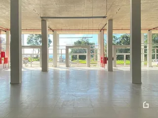 Espaço interno amplo com grandes vãos e colunas brancas.