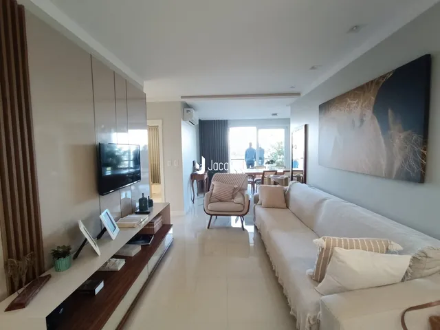 Sala de estar ampla com sofá e televisão em um apartamento.