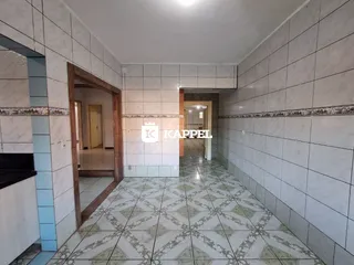 Corredor interno com piso de azulejos e paredes claras.