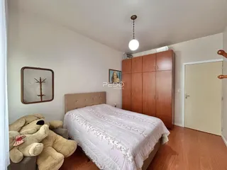 Quarto com cama e armário de madeira no interior da residência.