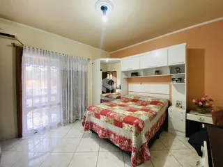 Quarto com cama e armários brancos em ambiente claro.