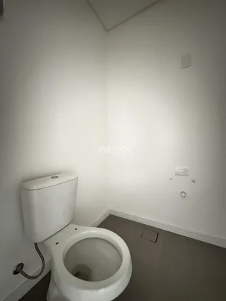 Foto de um banheiro simples com vaso sanitário branco.