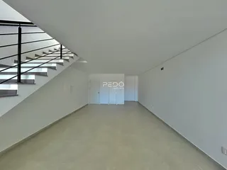 Hall de entrada com escadaria e paredes brancas.