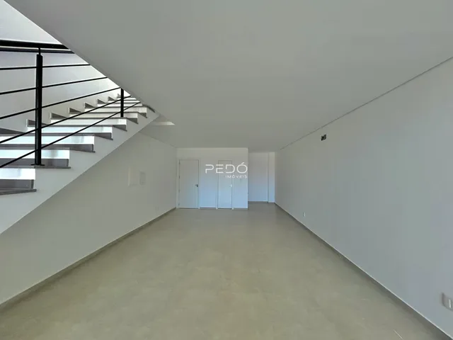 Hall de entrada com escadaria e paredes brancas.