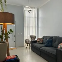 Foto de uma sala de estar com sofá e cortinas verticais.