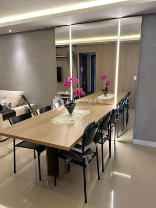 Mesa de jantar de madeira com cadeiras em um ambiente interno.