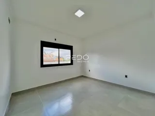 Uma sala vazia com uma grande janela de destaque.