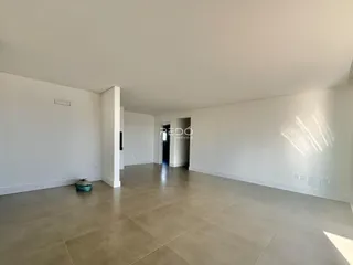 Ambiente interno amplo com piso de cerâmica claro.