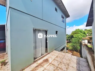 Fachada externa de uma residência em Lajeado, Brasil com piso de ladrilhos claros.