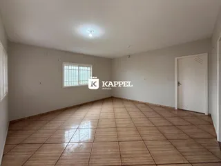 Uma foto de uma sala ampla com piso de cerâmica e uma janela.