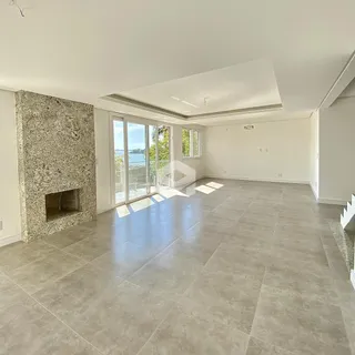 Sala de estar ampla com piso de cerâmica e parede de pedra.