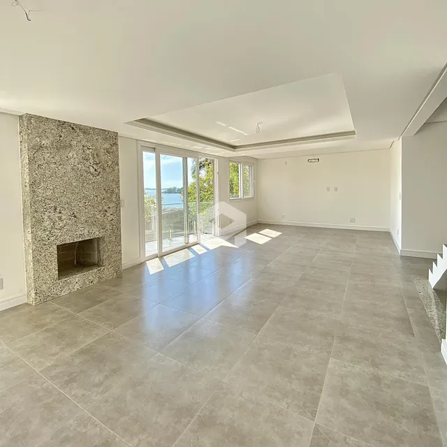 Sala de estar ampla com piso de cerâmica e parede de pedra.