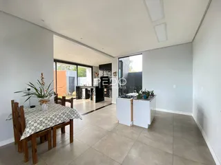 Ambiente de sala de estar e jantar com piso de porcelanato claro.