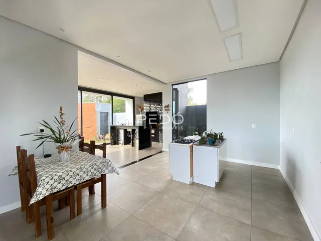 Ambiente de sala de estar e jantar com piso de porcelanato claro.