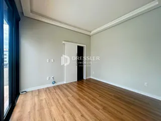 Ambiente interno com piso de madeira e paredes claras.