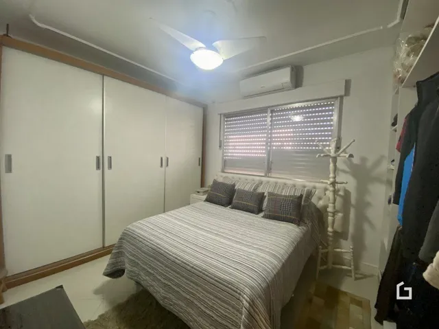 Quarto com armários embutidos e cama de casal.