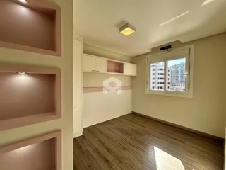 Ambiente interno com piso de madeira e janela.