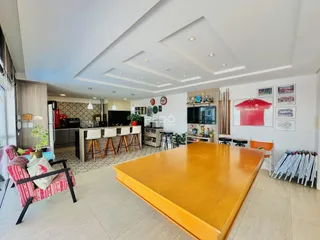 Ambiente moderno de sala de jantar e cozinha com piso claro.