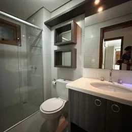 Foto de um banheiro interno mostrando um vaso sanitário e uma divisória de vidro.