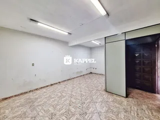 Foto de um cômodo amplo com paredes brancas e piso de cerâmica.