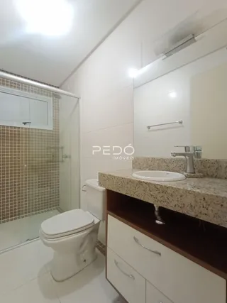 Foto de um banheiro com revestimento de azulejos claros e piso branco.