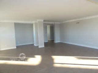Vista interna de um ambiente amplo com piso de madeira.