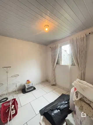 Quarto interno com paredes brancas e piso de cerâmica.