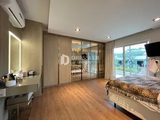 Quarto espaçoso com piso de madeira e portas de vidro que dão para o exterior.