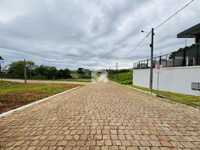 Uma estrada pavimentada se estende ao longo de uma propriedade com cerca branca.
