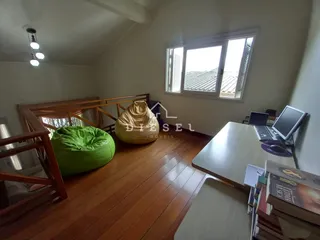 Ambiente interno de uma sala com piso de madeira e janela.