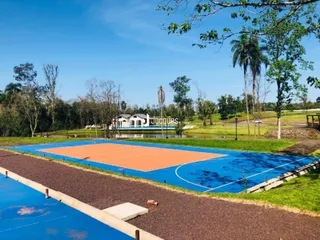 Uma vista externa de um campo esportivo gramado em uma propriedade.