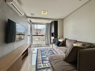 Sala de estar com sofá e televisão em um apartamento.