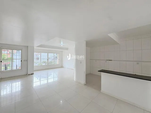 Ambiente interno amplo com piso de cerâmica claro e paredes brancas.