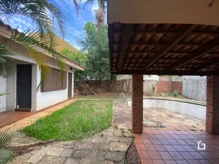 Área externa com gramado e piso de tijolo no quintal da propriedade.