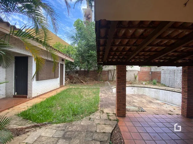 Área externa com gramado e piso de tijolo no quintal da propriedade.